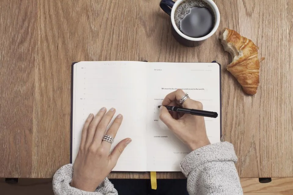 Aantekeningen in een notitieboek, met koffie ernaast